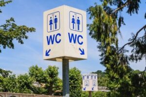 street-toilet-sign,-tourists-help-service-on-blue-sky-cm