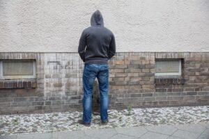 Man-In-Hood-Peeing-On-Wall--cm