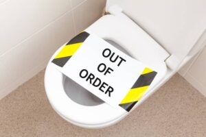 Household toilet with a sign that reads 'out of order'-cm