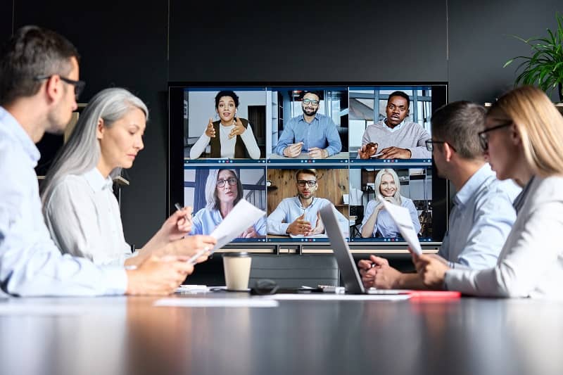 online videoconference in meeting room with diverse people sitting in modern office and multicultural multiethnic colleagues on big screen monitor-cm