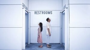 Confused Couple Looking Up at Restroom Signs-cm